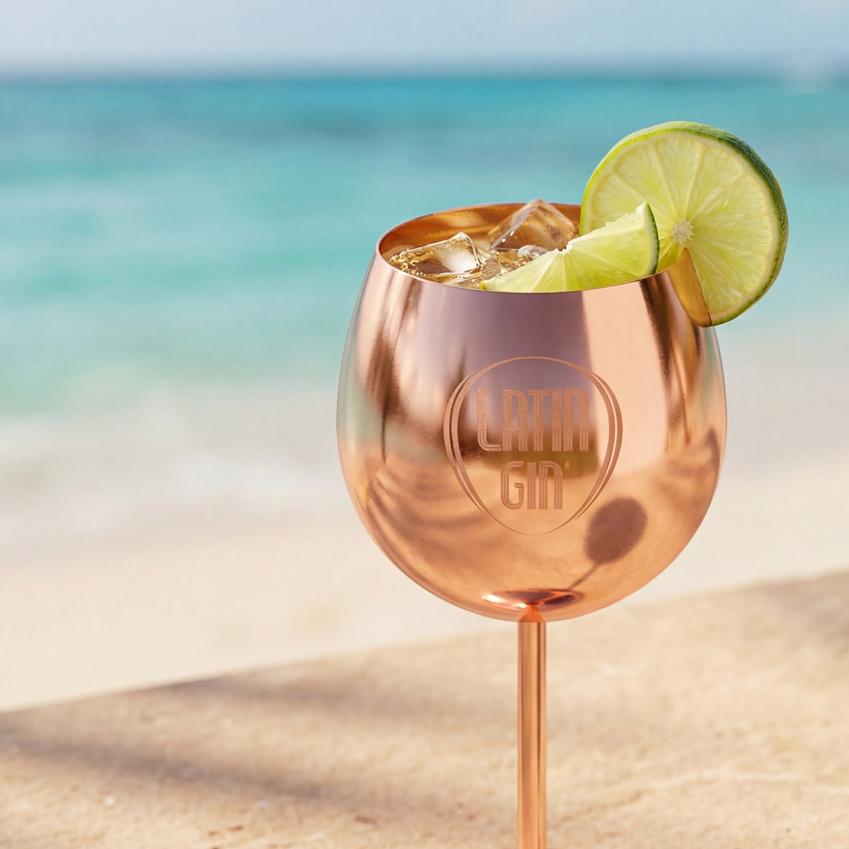 Rose gold Latin Gin Copa cup with a gin cocktail, ice and lime by the sea