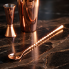 Latin Gin rose gold bar spoon with a twisted handle alongside matching barware